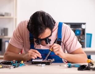 The young male contractor repairing computer