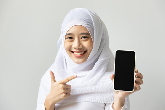 Happy smiling muslim woman pointing at smartphone black screen