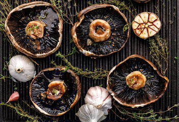 Grilled portobello mushrooms with herbs and garlic on a grill plate, close up view - 531467944