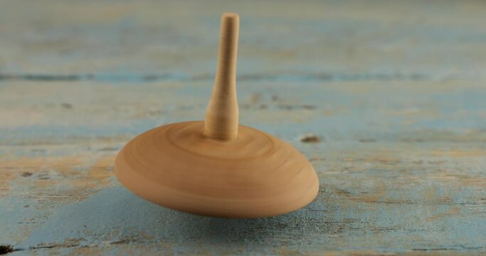 Peg toy or whirligig rotates on a vintage wooden board.