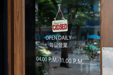 sorry we are closed sign hanging outside a restaurant, store, office or other