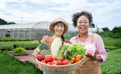 Portrait of smiling woman seasonal farm worker owner posing with crate of freshly picked lettuce on vegetables field.Bank for agriculture money saving.Successful Agribusiness selling delivery fruit.