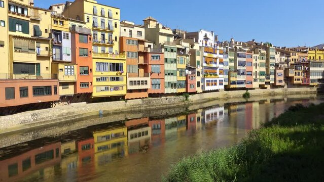 Colorful houses next to the Onyar River that are reflected in the water in the Catalan city of Girona.