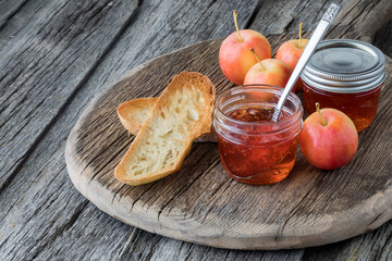 A small jar of crab apple jelly with dry toast ready for topping.