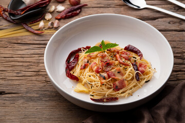 Stir-Fried Capellini pasta With Dried Chili And Crispy Bacon on white plate