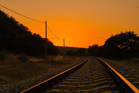 Railway tracks in sunset reflection. Evening landscape on the railroad