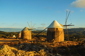 Windmills at sunset, mountain landscape. Old windmills on top of the mountain