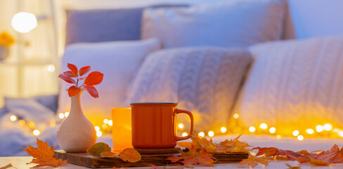 cup of tea and  autumnal leaves in cozy interior