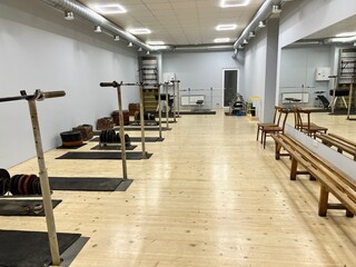 Fototapeta na wymiar Gym and equipment. Premises for training weightlifters. Old simulators for pumping muscle mass. Fitness room. A gym with exercise machines. Squat deadlift with a barbell.