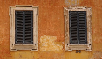 Colorful Old House Facade with Windows with Closed Shutters Close Up in Rome, Italy