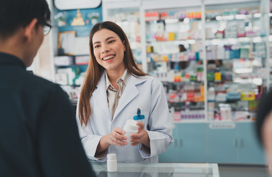 female pharmacist at drugstore.Health care pharmacists work at the hospital.Pharmacist looking at male customer.Doctor specialists organize prescription medications.