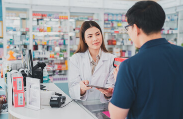 Obraz premium female pharmacist at drugstore.Health care pharmacists work at the hospital.Pharmacist looking at male customer.Doctor specialists organize prescription medications.