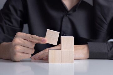 The man's hand placed a wooden cube on table. Business strategy and plan. Copy space. Mockup for letters, symbol, picture text, word, idea, concept