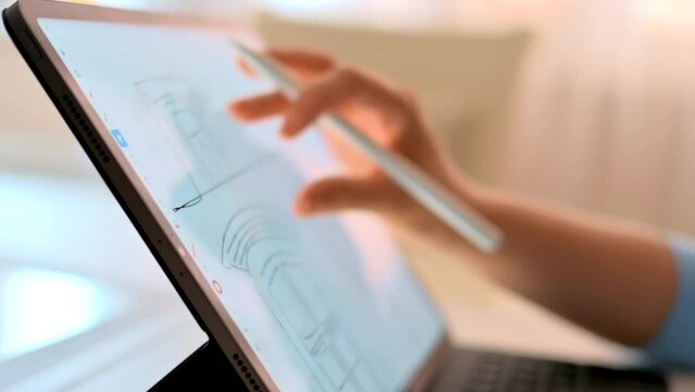 Woman drawing on a tablet with white pencil, close up