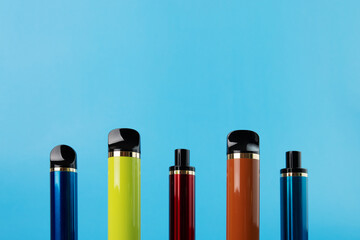 disposable vapes, different electronic cigarettes on a blue background, copy space