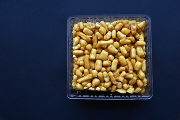 Sweet snack chuck-chuck in a package on a black background. Honey snack made of dough.