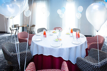 Beautiful table setting with dishes and flowers for a party, birthday, reception or other festive event. Glassware and cutlery for dinner.