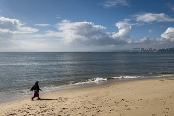 A woman walking on the beach in Lisbon