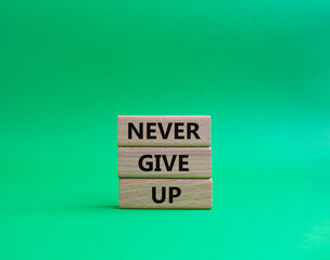 Never give up symbol. Concept words Never give up on wooden blocks. Beautiful green background. Business and Never give up concept. Copy space.