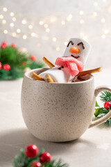 Mug with hot chocolate with melted marshmallow snowman. Merry Christmas drink. Happy Holiday card