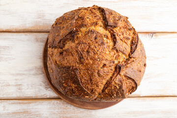 Fresh homemade golden grain bread with wheat and rye on white, top view, close up.