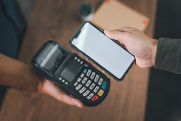 Customer pays bills via smartphone using NFC technology. Close-up of a contactless hand-picked...