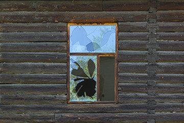 Broken window in an old abandoned wooden house.