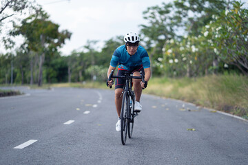 Fototapeta na wymiar Asian man Cyclist Riding On Road Bike In City Park.