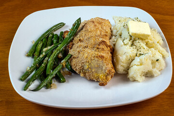 baked chicken thigh with  sauteed green beans and mashedpotatoes