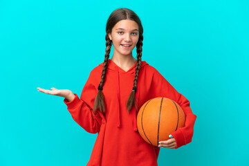 Little caucasian girl playing basketball isolated on blue background with shocked facial expression