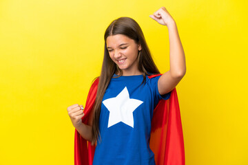 Little caucasian superhero girl isolated on yellow background celebrating a victory © luismolinero