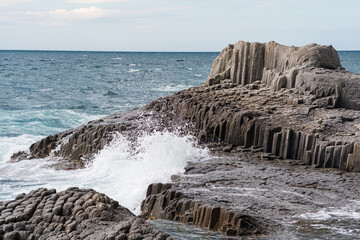 rocks formed by columnar basalt among the sea surf, Cape Stolbchaty on Kunashir Island