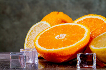 Lemons and oranges with ice. Preparation of a cocktail of citrus fruits.