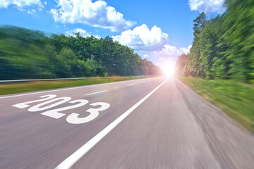 Road with the inscription 2023 moving towards the sun ahead. The concept of achieving goals in the...