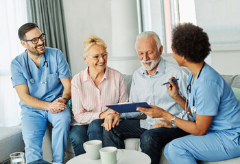 nurse doctor senior couple care caregiver help assistence retirement home nursing elderly man woman contract agreement document signature insurance explaining