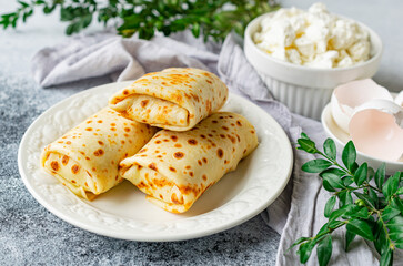 Pancakes stuffed with cottage cheese and herbs on a white plate