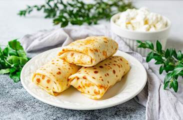 Pancakes stuffed with cottage cheese and herbs on a white plate