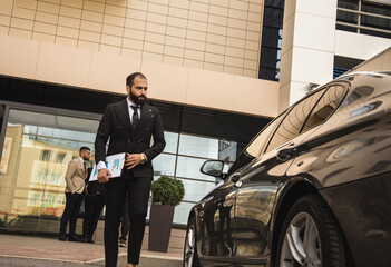 An Arab man in a suit approaches his car. Business space and promotion. Service and customer service. business lifestyle
