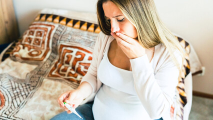 Pregnancy fever temperature check. Pregnant woman holding thermometer, check fever flu temperature. Pregnancy girl sick. Concept maternity, pregnant, childbirth.