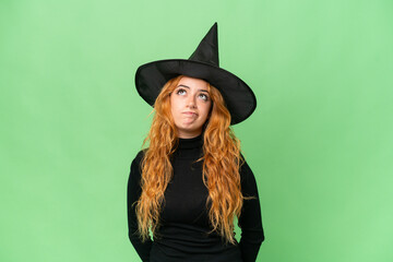 Fototapeta premium Young caucasian woman costume as witch isolated on green screen chroma key background and looking up