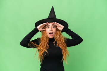 Young caucasian woman costume as witch isolated on green screen chroma key background with surprise expression