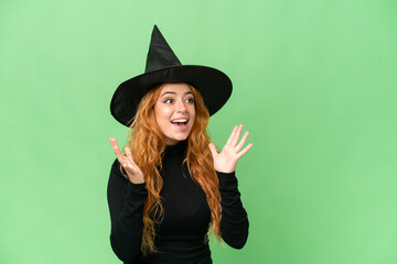 Young caucasian woman costume as witch isolated on green screen chroma key background with surprise facial expression