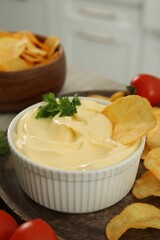 Potato chips with mayonnaise on wooden tray, closeup