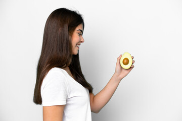 Young Brazilian woman holding an avocado isolated on white background with happy expression