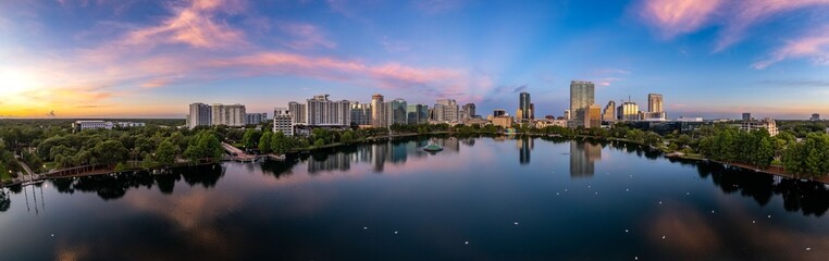 Panoramic shot of lake Eola and the Orlando city skyline at sunrise - obrazy, fototapety, plakaty