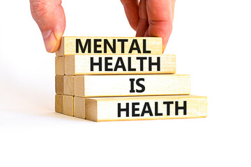 Mental health psychological symbol. Concept words Mental health is health on wooden blocks on a beautiful white table white background. Psychologist hand. Psychological mental health concept.