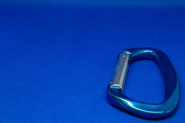 Aluminium carabiners for climbing on a blue background. Metal connectors for mountaineering close-up