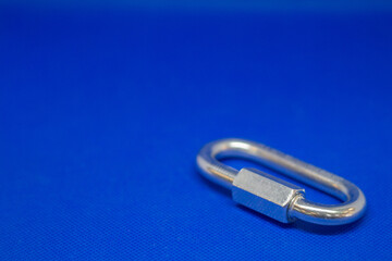 Strong steel carabiners for mountaineering and industrial work. Metal connectors for work on hight on a blue background