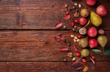 Fototapeta premium Festive traditional thanksgiving wooden background. Composition of pears, apples, nuts, dry leaves. Top view.