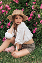 beautiful girl among pink roses outside